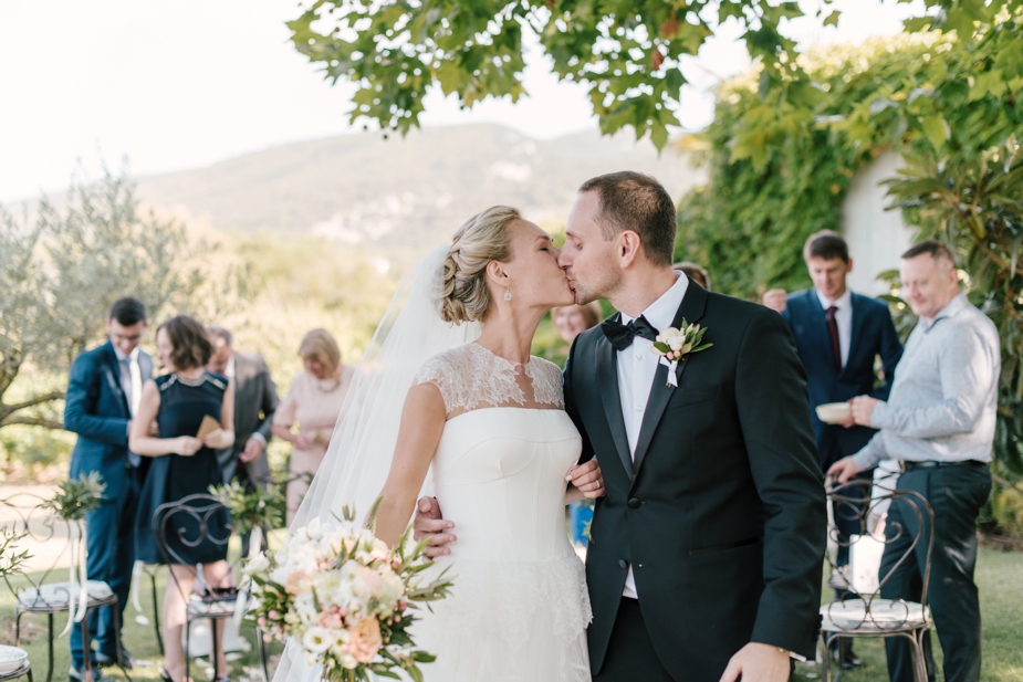 bride and groom walking down the aisle kissing at Villa Grenache