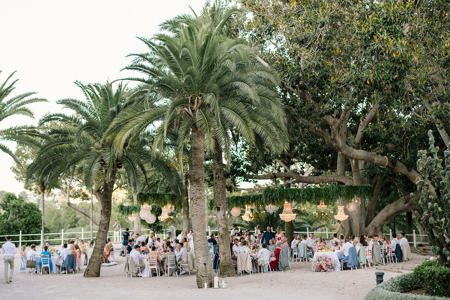 wedding dinner under palm trees at  bendinat castle in mallorca